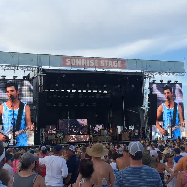 A live outdoor performance engages a large audience.
